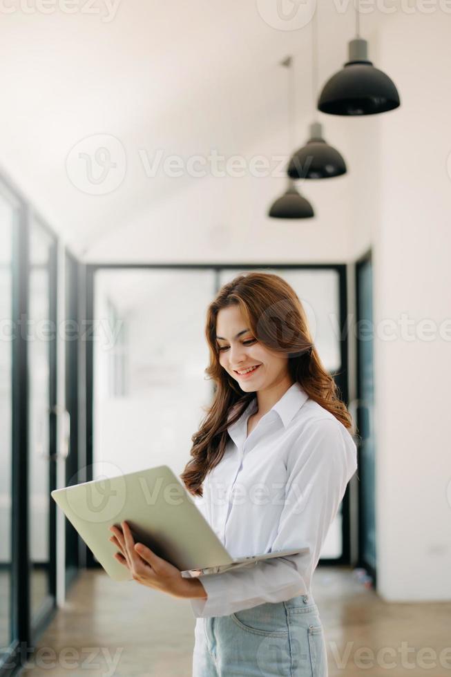 berufstätiges frauenkonzept eine weibliche managerin, die an einer videokonferenz teilnimmt und tablet, smatrphone und eine tasse kaffee im büro hält foto