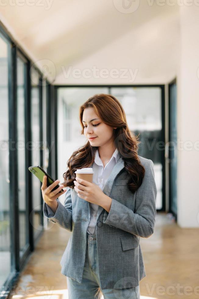 berufstätiges frauenkonzept eine weibliche managerin, die an einer videokonferenz teilnimmt und tablet, smatrphone und eine tasse kaffee im büro hält foto