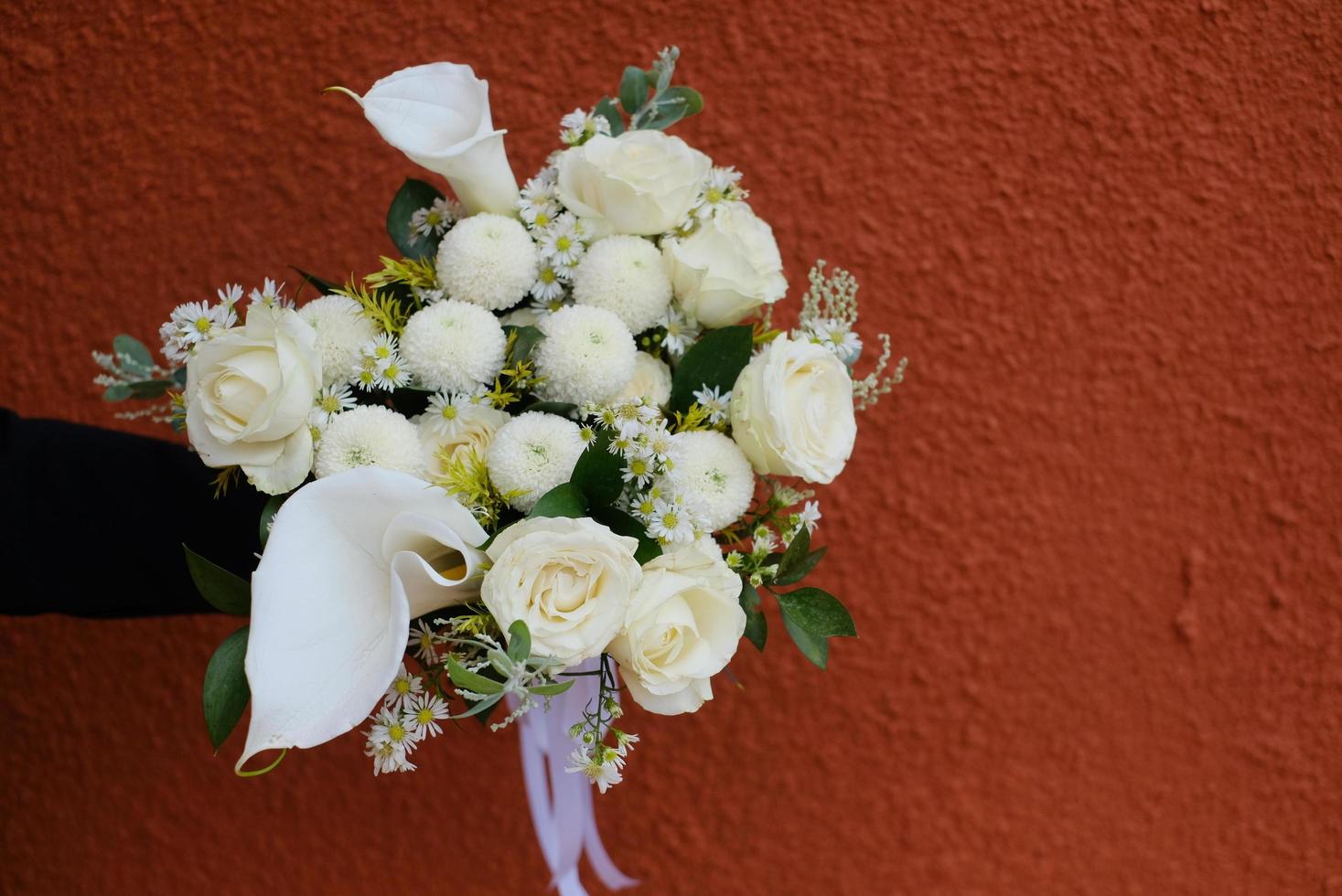 Blume Eimer im Hand gegen rot Mauer Hintergrund foto