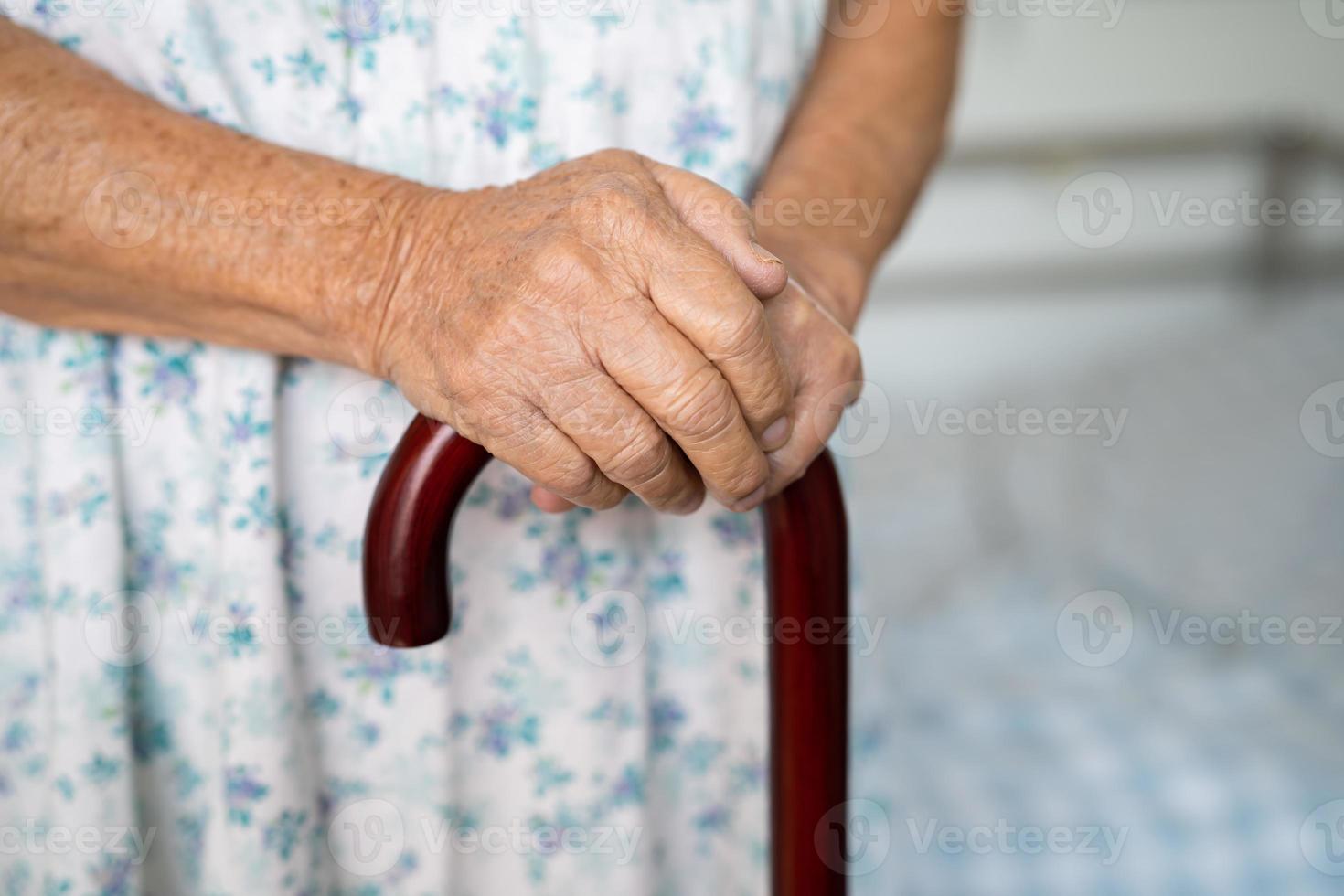 asiatisch Alten Behinderung Frau halten wackeln Stock, Holz Stock, runden handhaben, Gehen Hilfe zum Hilfe zu gehen. foto