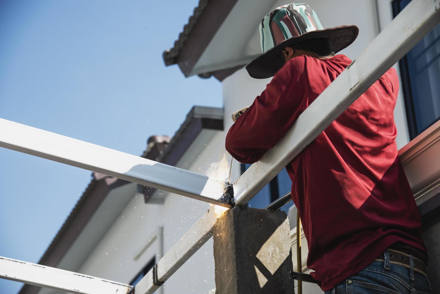 vor Ort Konstruktion Arbeiter mit Stahl Dach Struktur Installation, Wohn Gebäude Auftragnehmer Job foto