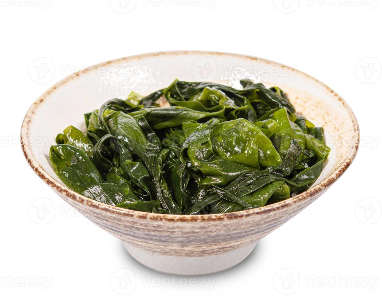 Laminaria Seetang Seetang im schwarz Schüssel isoliert auf Weiß Hintergrund. miyeok muchim. Koreanisch Seetang Salat foto