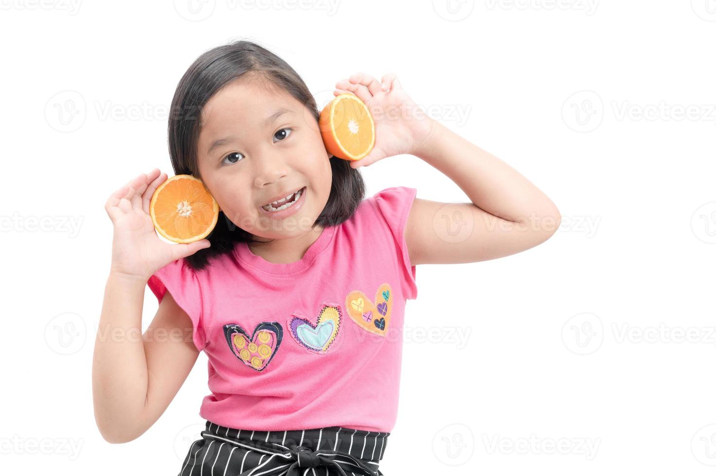 süß asiatisch Mädchen spielen mit frisch Mandarin Früchte foto