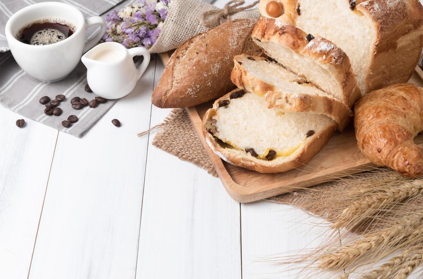 gebacken Brot und Weizen auf Weiß Holz Hintergrund foto