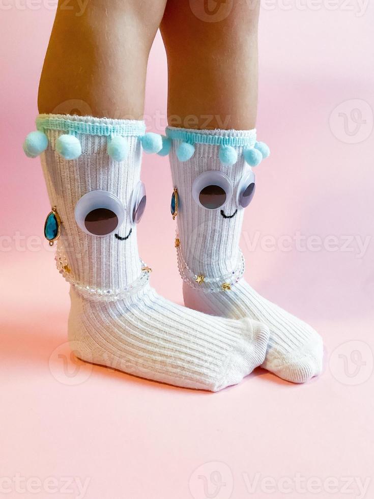 Baby Socken mit Augen und Lächeln auf Rosa Hintergrund foto