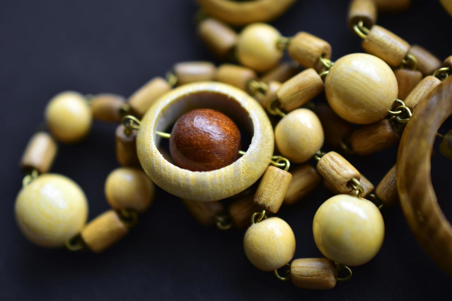 schöne runde Perlen aus Holz auf schwarzem Hintergrund foto