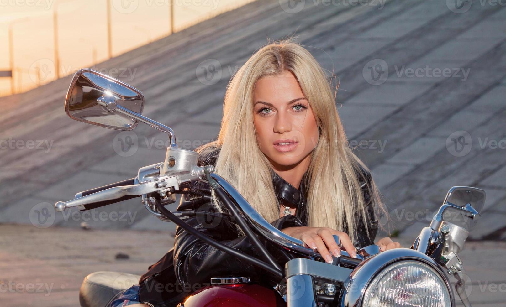 sexy Blondine sitzt auf ihrem Motorrad foto