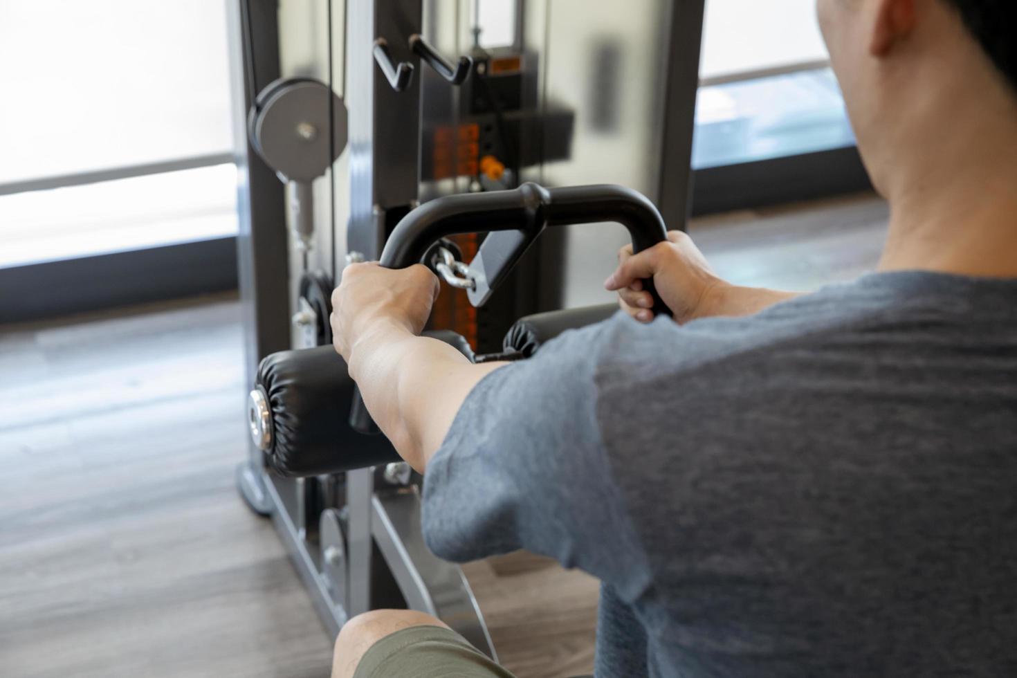 Anfänger des jungen Mannes, der mit Hanteln trainiert, die Muskeln an einer Turnhalle, Sporttrainingskonzept biegen foto