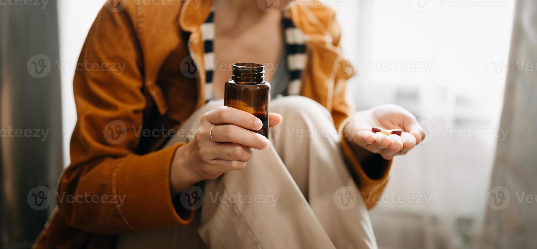 Frauenhand, die eine Flasche mit Pillen in der Hand hält, um die von seinem Arzt verschriebenen Medikamente einzunehmen foto