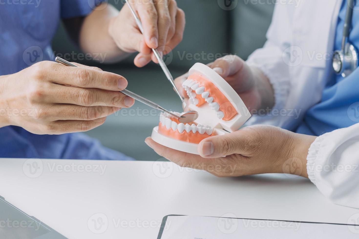 zahnärzte diskutieren zahnprobleme und melden den patienten ein röntgenbild auf einem laptop-bildschirm. foto