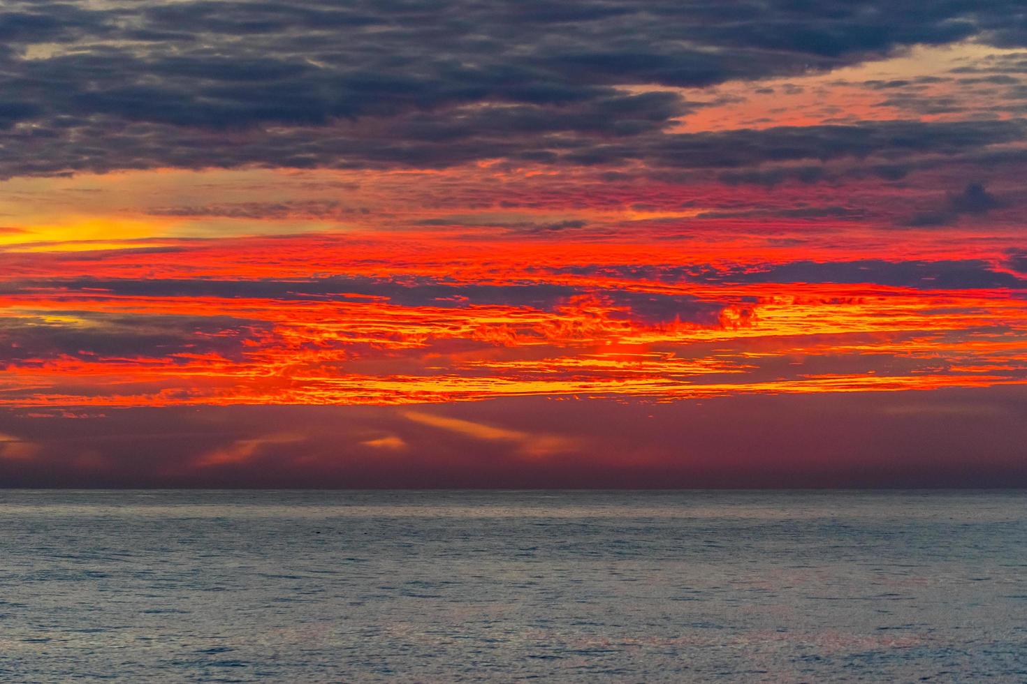 bunter orange und roter Sonnenuntergang über einem Gewässer foto