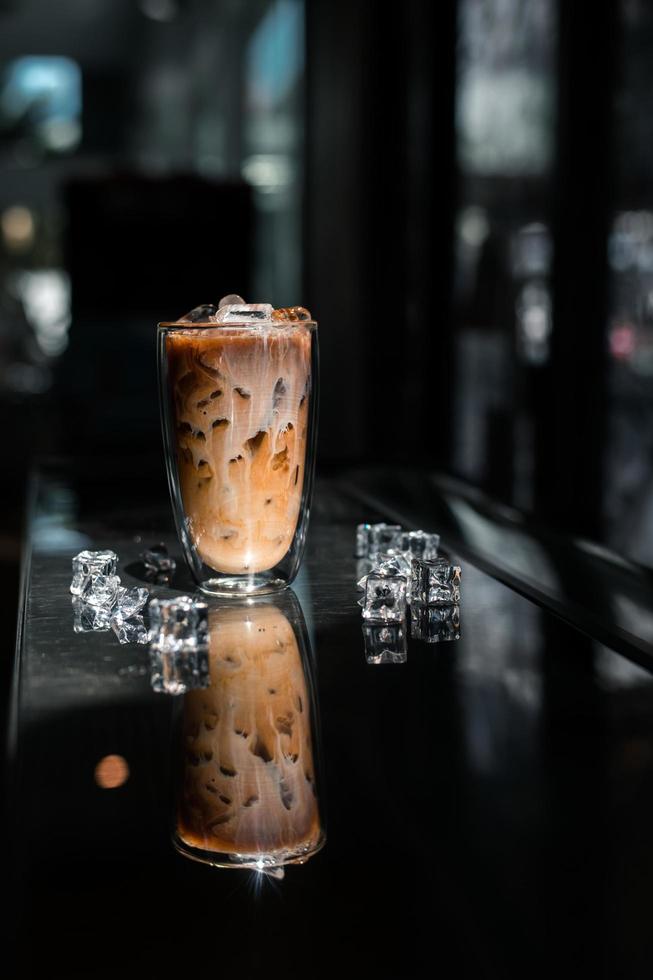 Nahaufnahme Glas Eiskaffee mit Milch auf dem Tisch foto