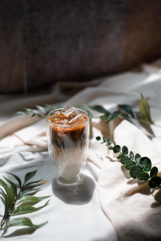 Nahaufnahme Glas Eiskaffee mit Milch auf dem Tisch foto