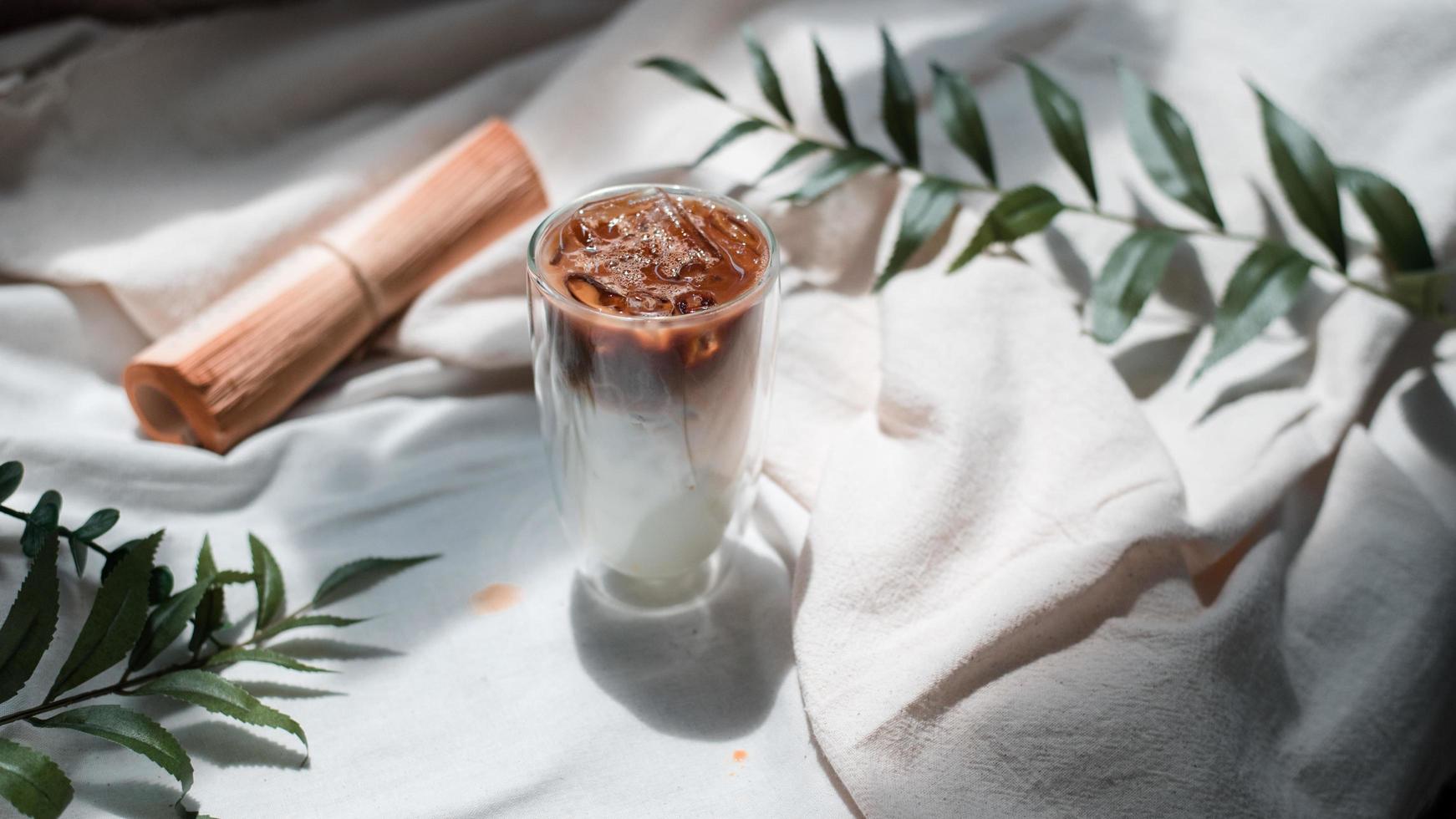 Nahaufnahme Glas Eiskaffee mit Milch auf dem Tisch foto