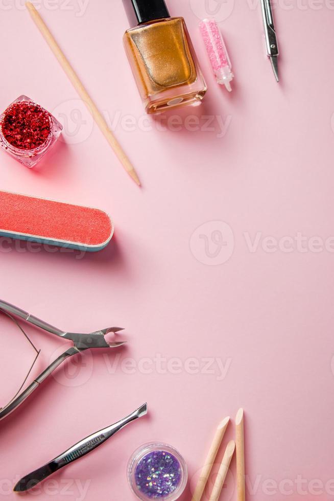 eine Reihe von Werkzeugen für Maniküre und Nagelpflege auf rosa Hintergrund. Arbeitsplatz in einem Schönheitssalon. Platz für Text. foto