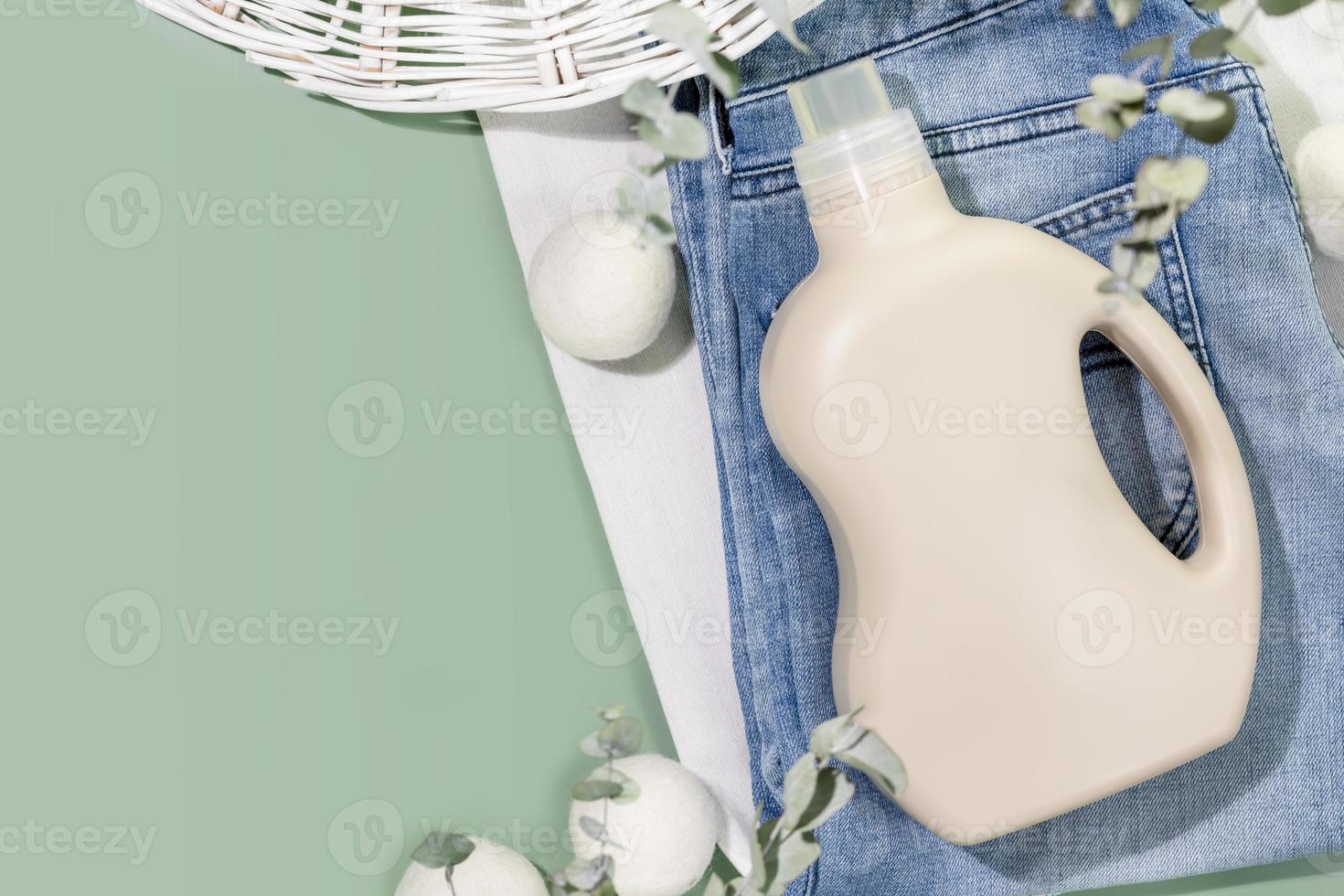 Flasche von Waschen Gel auf Kleider mit Wäsche Bälle auf Grün Hintergrund foto