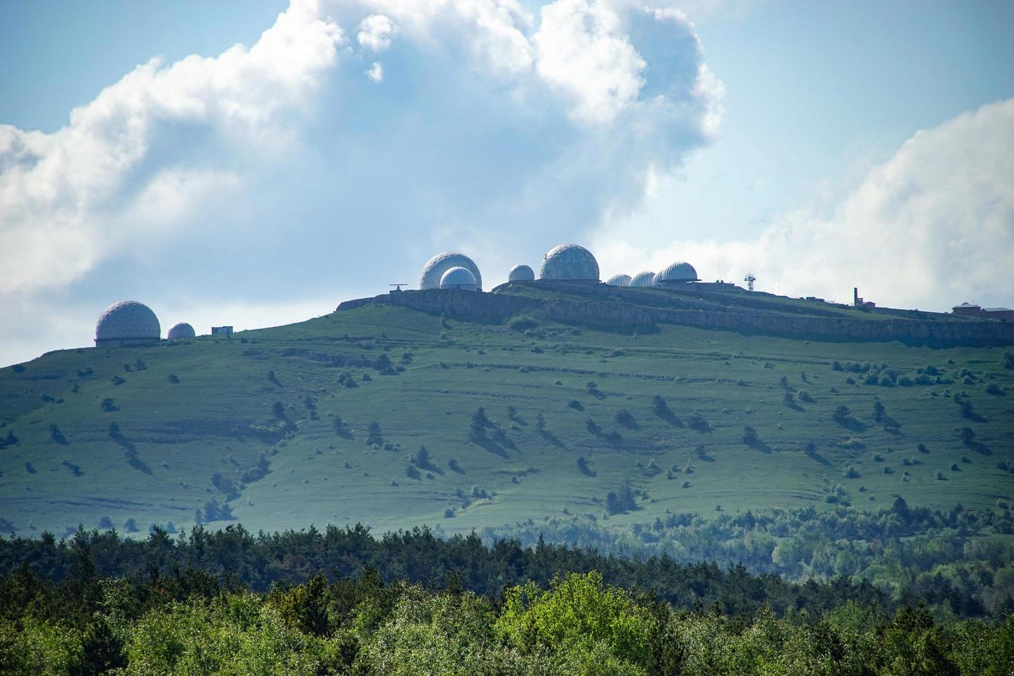 Landschaft mit geometrischen Gebäuden auf grünen Hügeln mit bewölktem blauem Himmel in Jalta, Krim foto