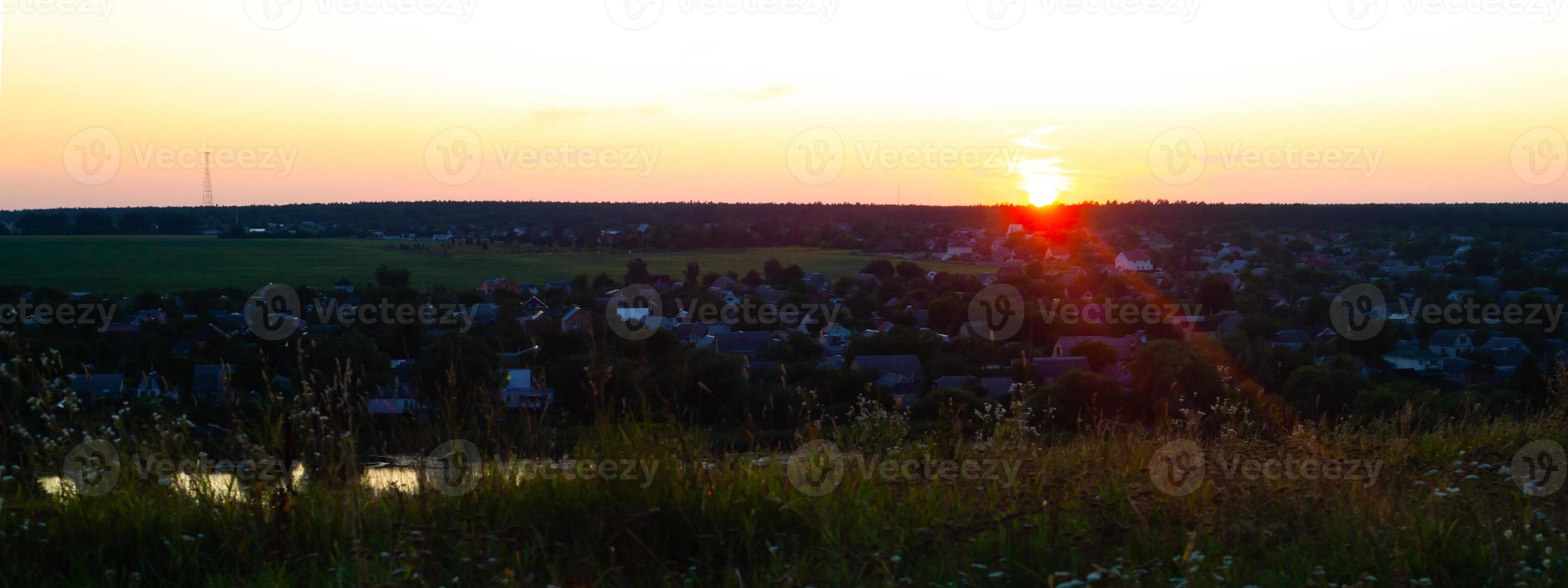 Panorama mit Blick auf das Dorf und die sterbende Sonne bei Sonnenuntergang. foto