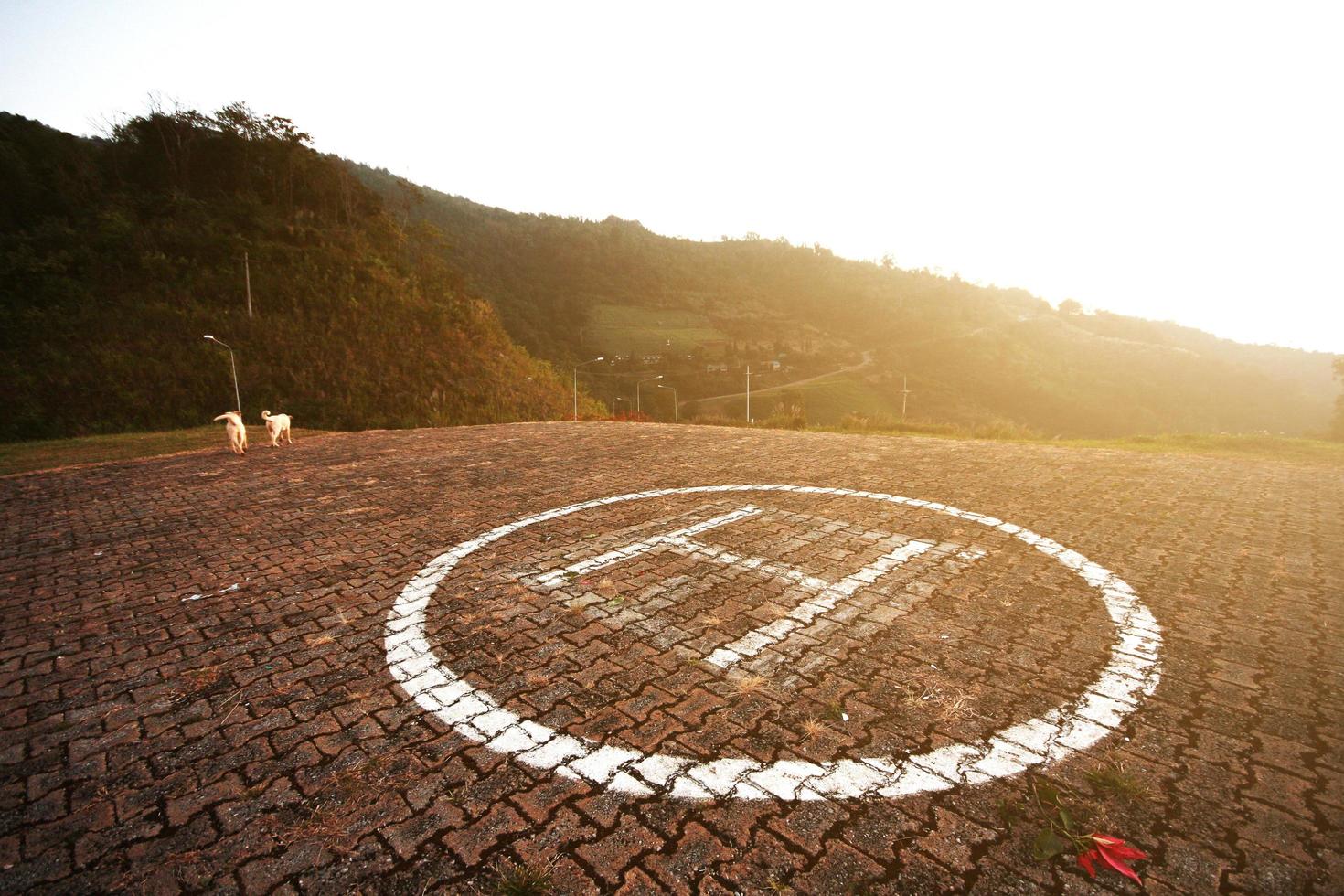 Hubschrauber Landung Symbol auf Beton Fußboden mit natürlich Sonnenuntergang auf das Berg. foto