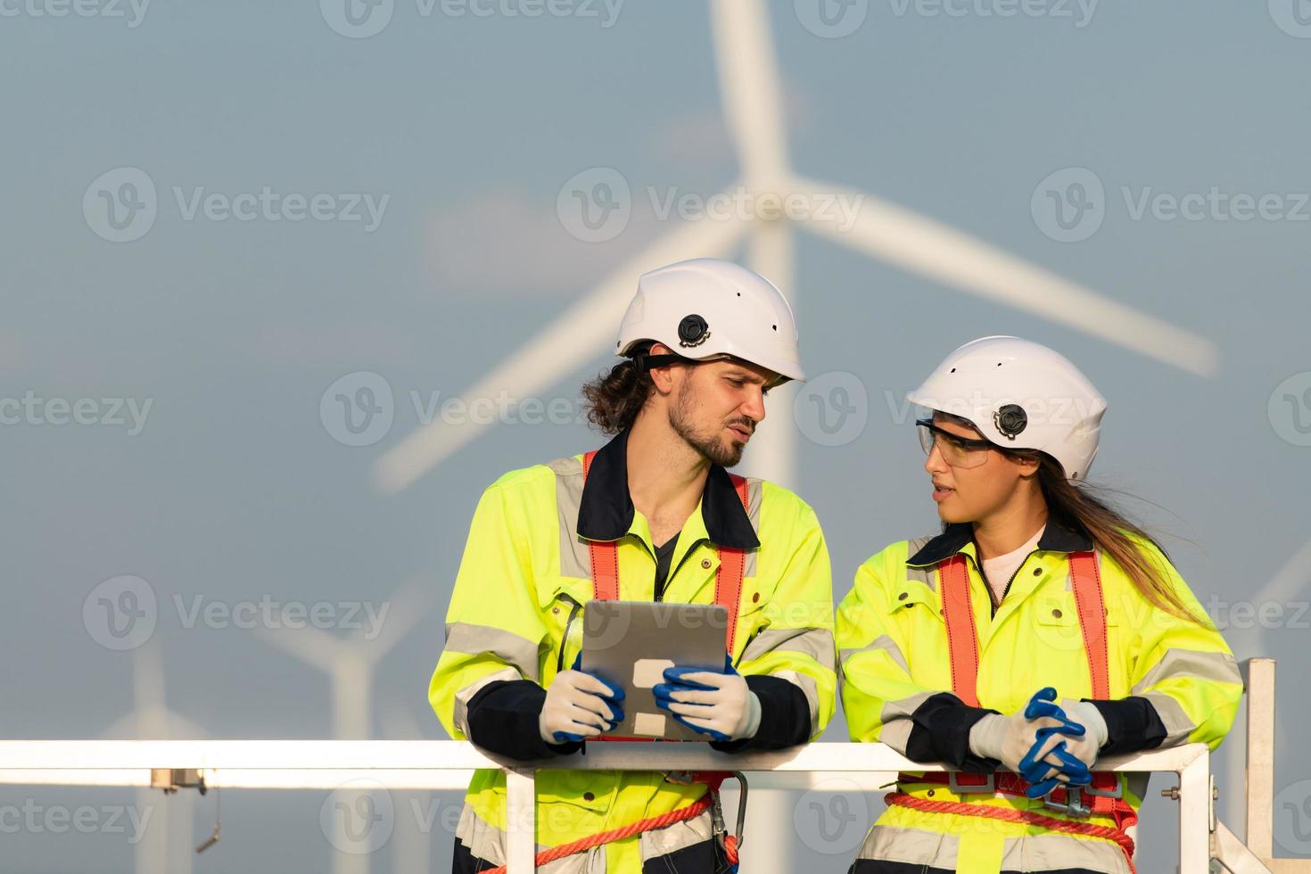 Mann und weiblich Ingenieur stationiert beim das natürlich Energie Wind Turbine Seite? ˅. mit Täglich Prüfung Aufgaben von Haupt Wind Turbine Operationen Das verwandeln Wind Energie in elektrisch Elektrizität foto