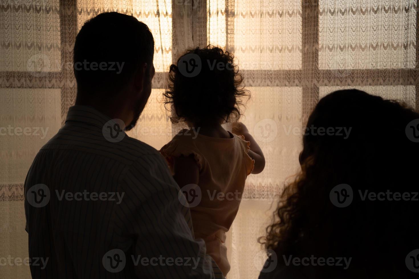 Eltern und Kinder genießen das Morgen Sonnenlicht leuchtenden durch das Schlafzimmer Fenster im das Haus. foto