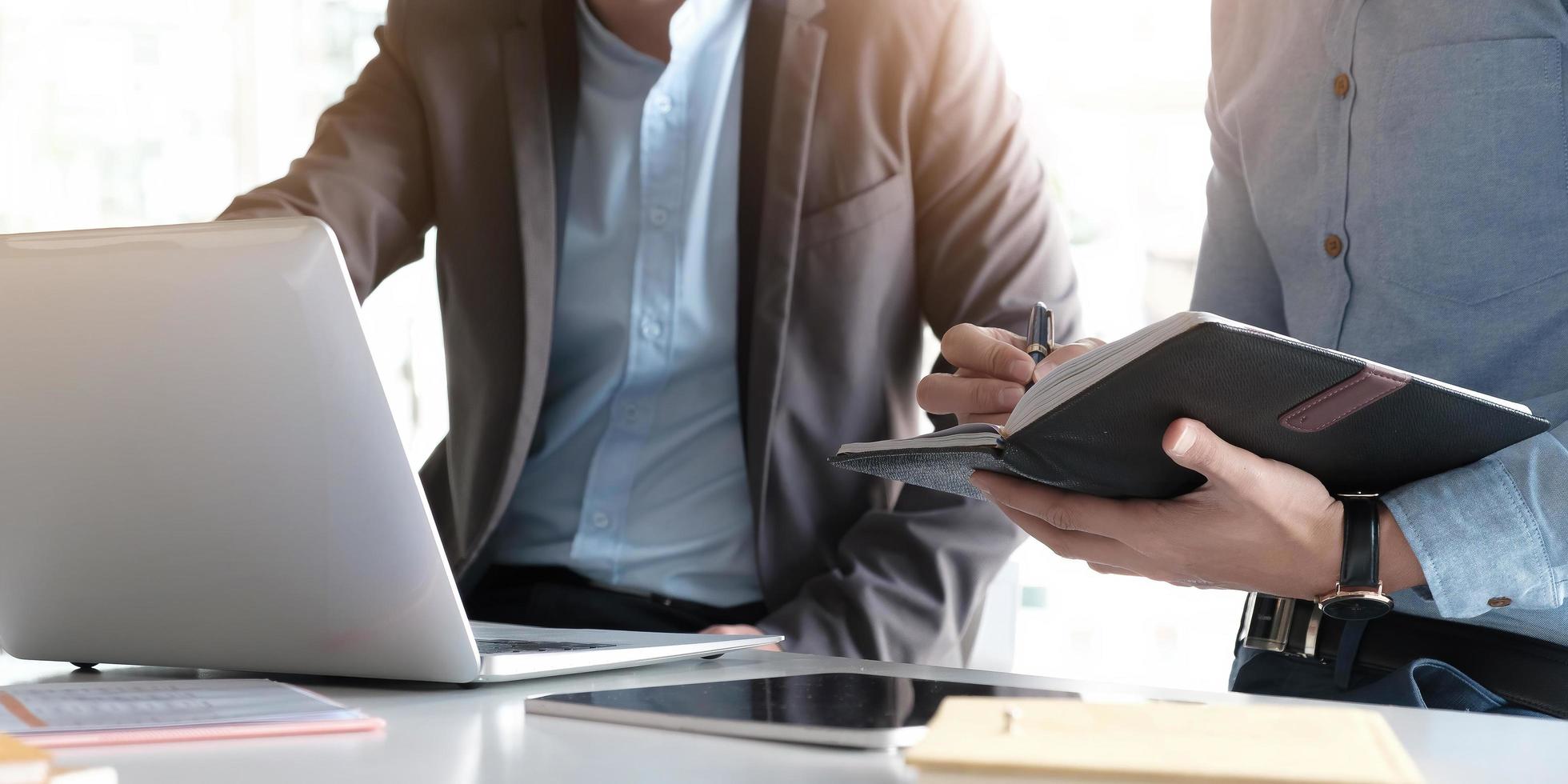 Profis, die ein Notebook und einen Laptop benutzen foto