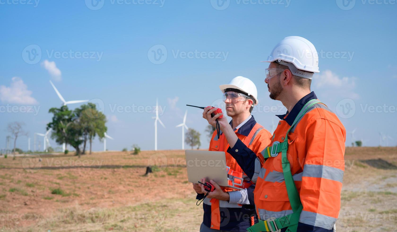 Landvermesser und Ingenieur untersuchen das Effizienz von riesig Wind Turbinen Das verwandeln Wind Energie in elektrisch Energie Das ist dann benutzt im Täglich Leben. foto