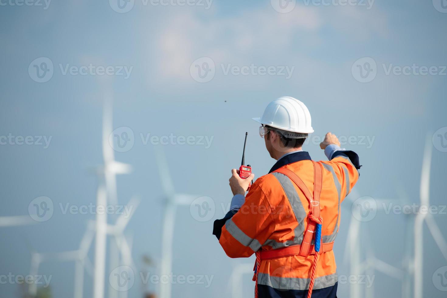 Ingenieur beim natürlich Energie Wind Turbine Seite? ˅ mit ein Mission zu nehmen Pflege von groß Wind Turbinen verwenden ein Walkie Talkie zu kommunizieren mit ein Kollege Arbeiten auf oben von das Wind Turbine. foto