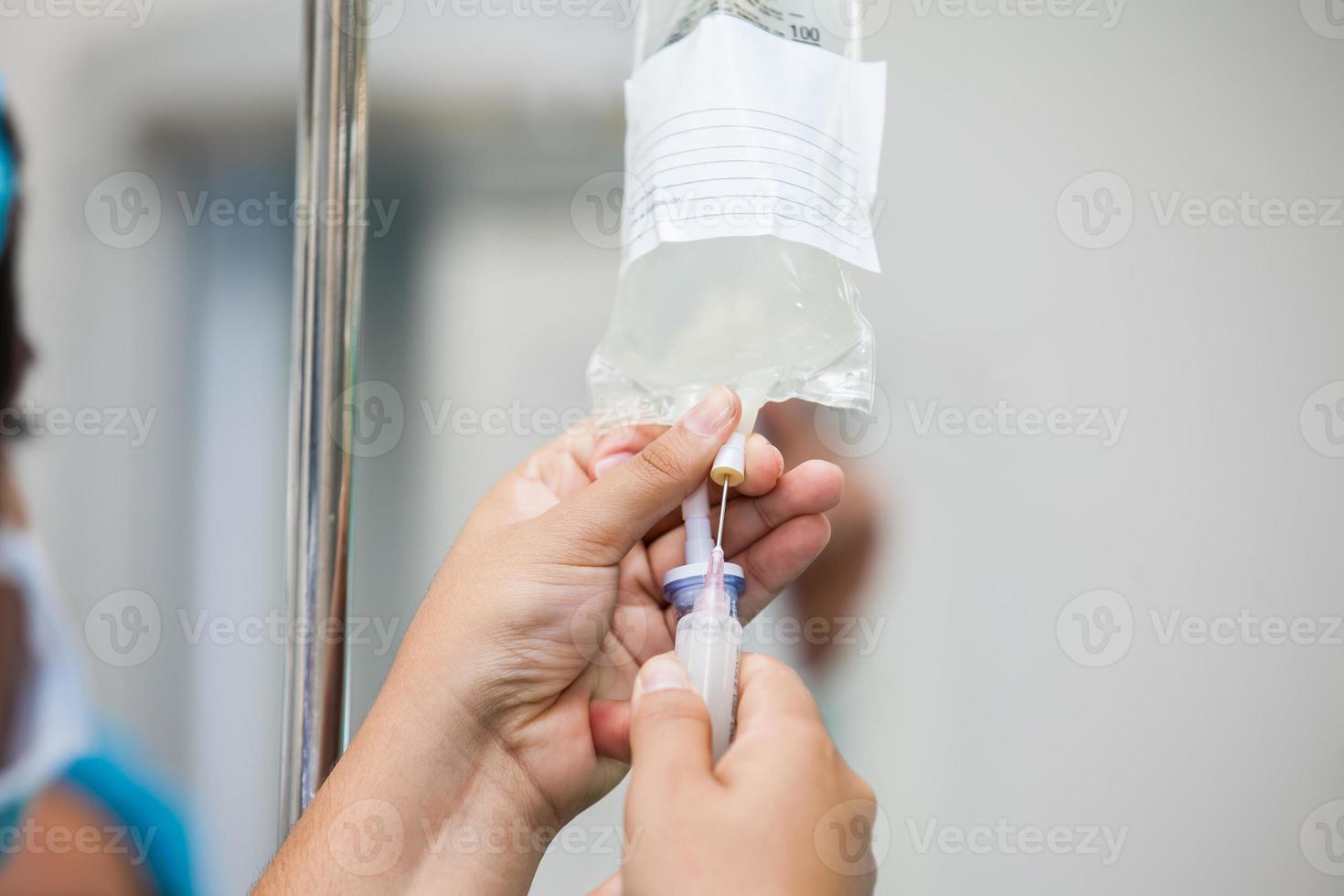 Krankenschwester spritzen ein Droge durch ein Infusion System foto