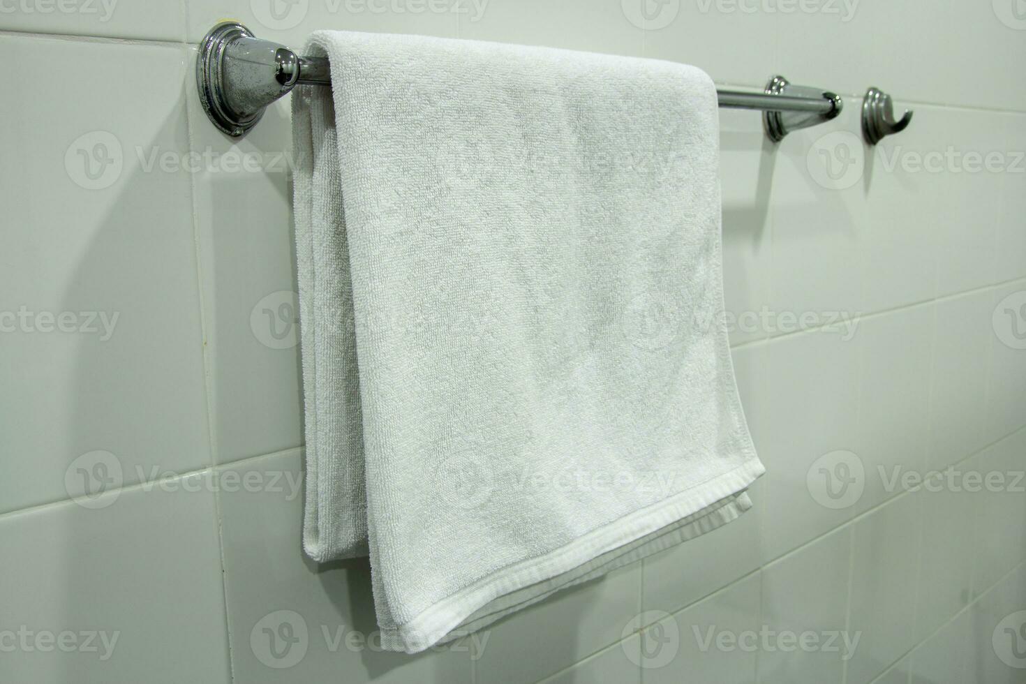 Weiß Bad Handtuch hängend auf das Badezimmer foto