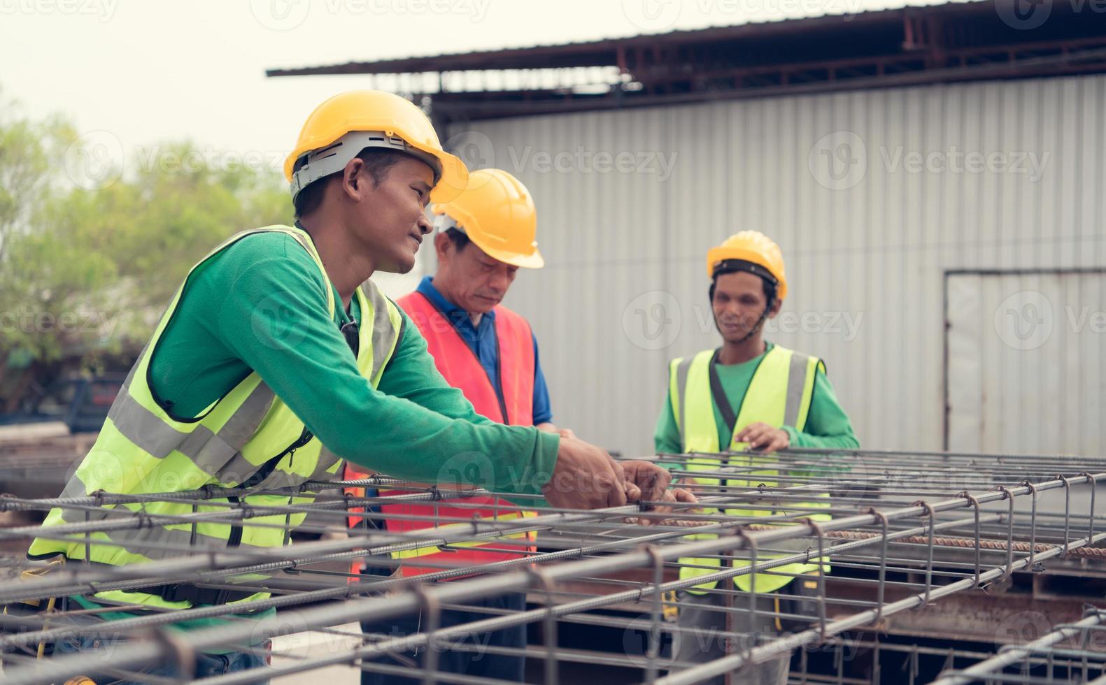Konstruktion Arbeiter ist binden das strukturell Stahl fest Dort ist ein Supervisor zu beraten und überwachen das Arbeit eng. foto