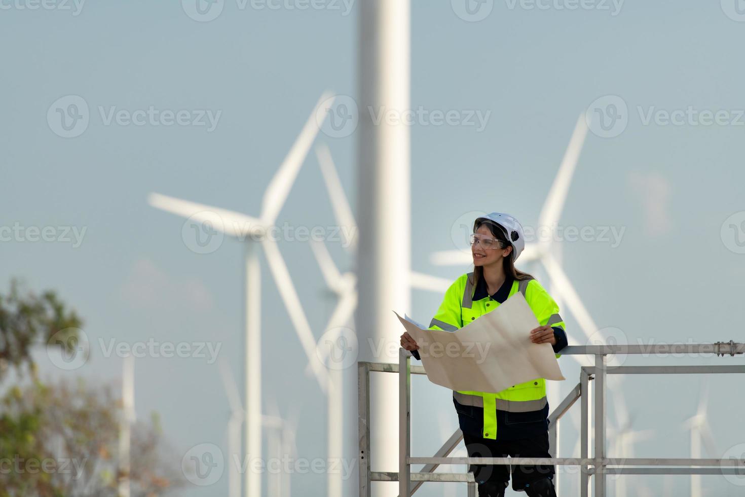 Porträt von weiblich Ingenieur beim natürlich Energie Wind Turbine Seite? ˅ mit das Mission von Sein verantwortlich zum nehmen Pflege von groß Wind Turbinen foto