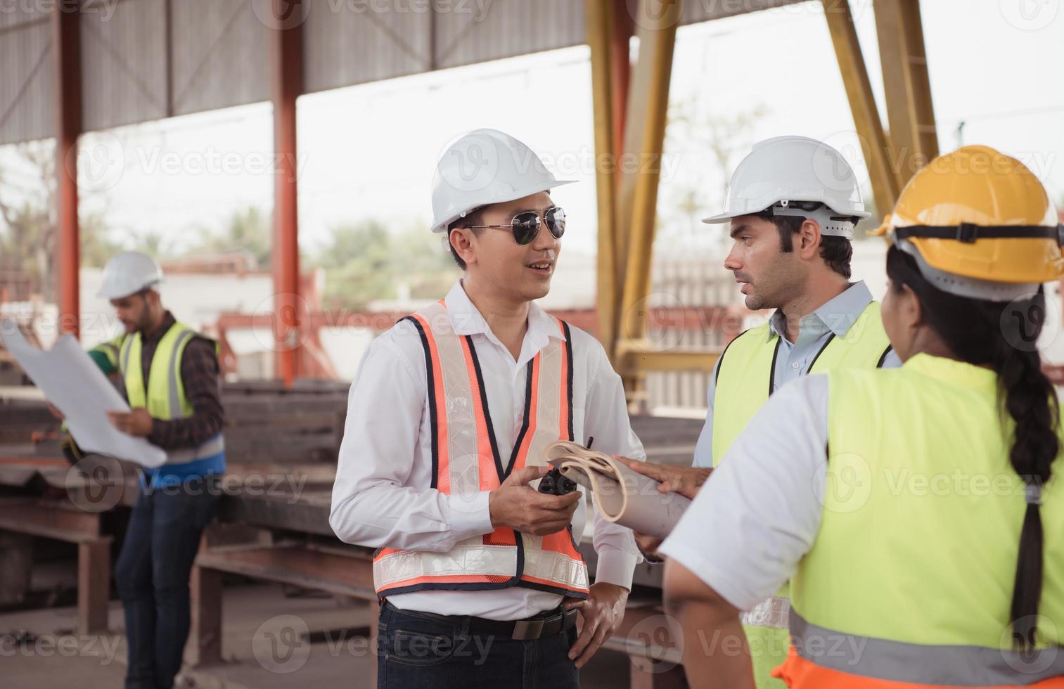 Gruppe von Architekten, Konstruktion Vorarbeiter, und Konstruktion Ingenieure Rezension das Arbeit und sich unterhalten Über Wie das Projekt, im das Konstruktion Seite? ˅. foto