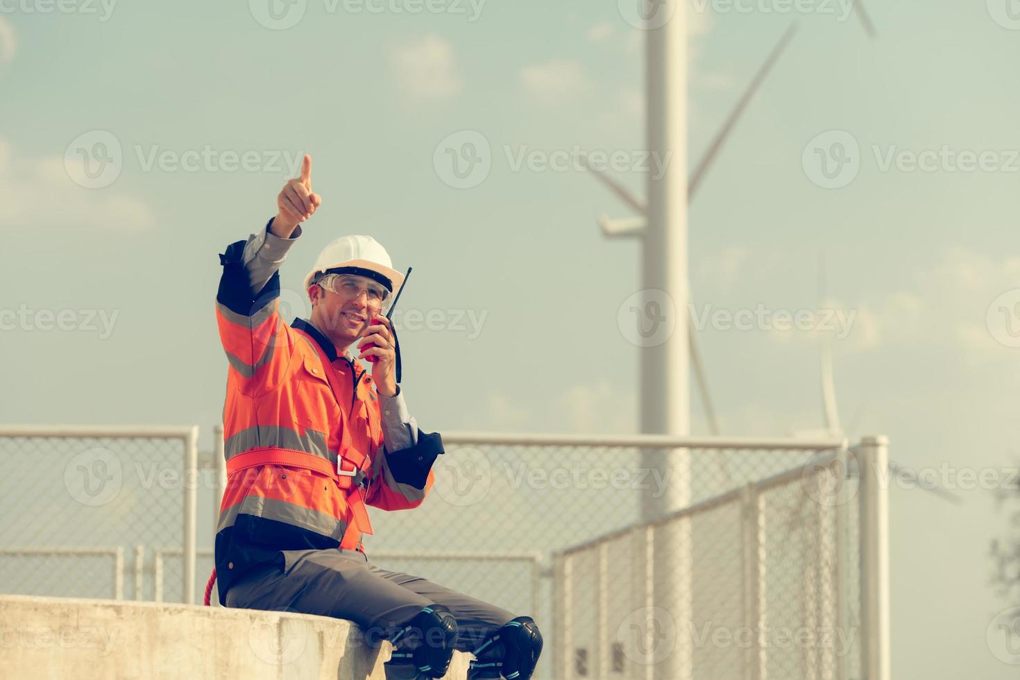 Ingenieur beim natürlich Energie Wind Turbine Seite? ˅ mit ein Mission zu nehmen Pflege von groß Wind Turbinen verwenden ein Walkie Talkie zu kommunizieren mit ein Kollege Arbeiten auf oben von das Wind Turbine. foto