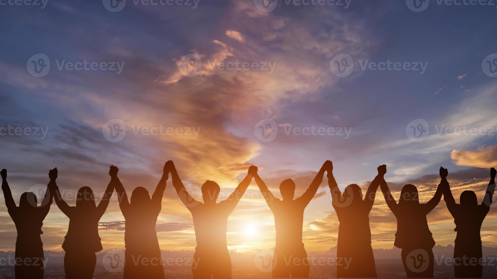 Silhouette von glücklich Geschäft Mensch Mannschaft Herstellung hoch Hände Über Kopf im Sonnenuntergang Himmel Abend Zeit Hintergrund zum Geschäft Zusammenarbeit Konzept und Freiheit foto