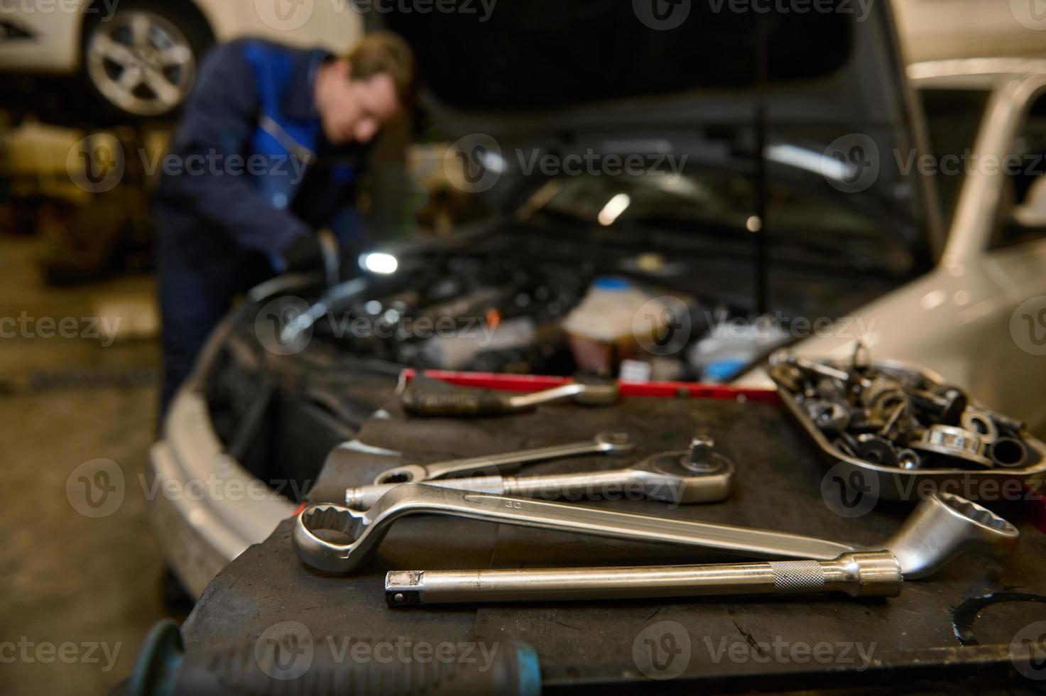 Fokus auf Schlüssel und Fachmann Werkzeuge zum reparieren und inspizieren Autos Lügen auf ein Schreibtisch foto