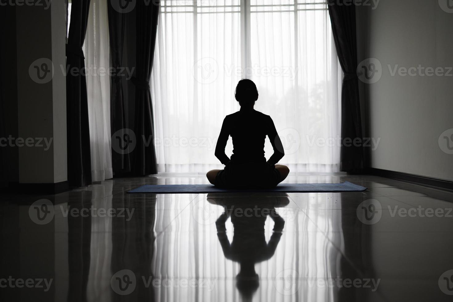 Silhouette jung Frau üben Yoga drinnen, meditieren, beten zum Gott. foto