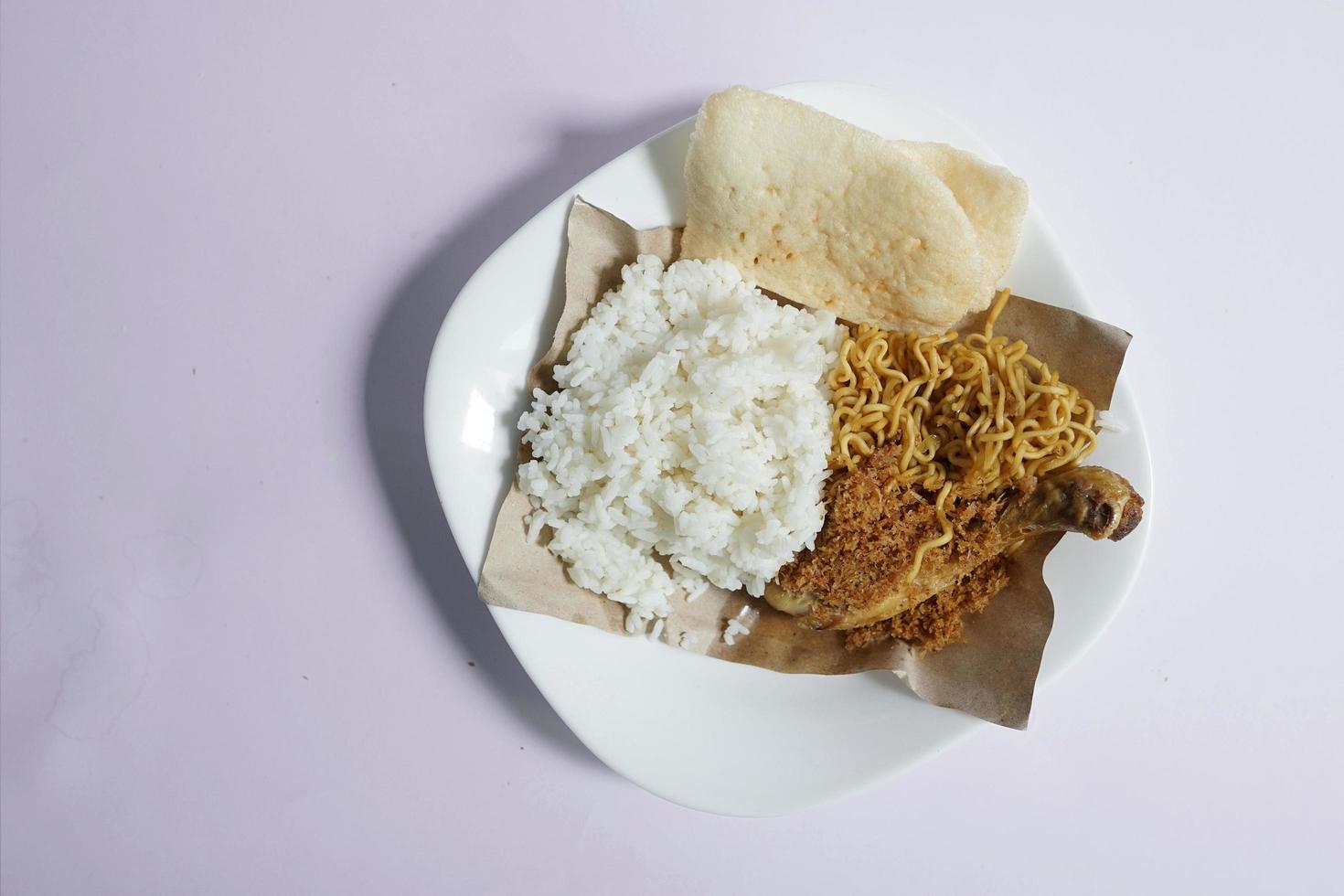 Padang Küche, Weiß Reis mit Hähnchen und gebraten Nudeln auf ein Weiß Teller auf ein einfach Hintergrund foto