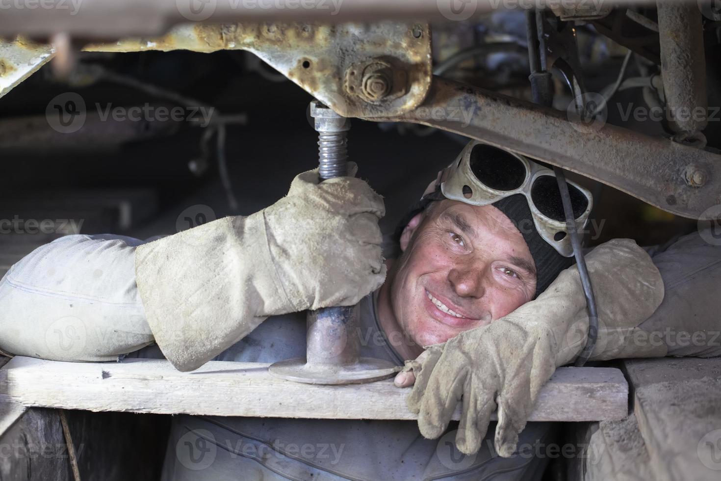 ein männlich Auto Mechaniker Instandsetzung ein Auto im ein garage.a Mann Instandsetzung ein Auto Körper. foto