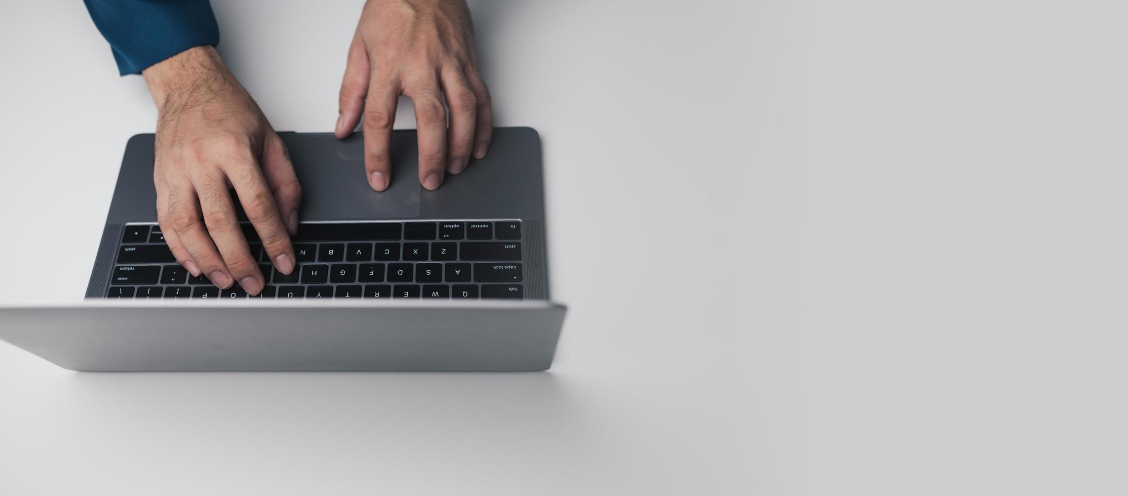 schließen oben Aussicht von Geschäftsmann mit Laptop Computer beim Büro Schreibtisch im das Büro Zimmer. foto