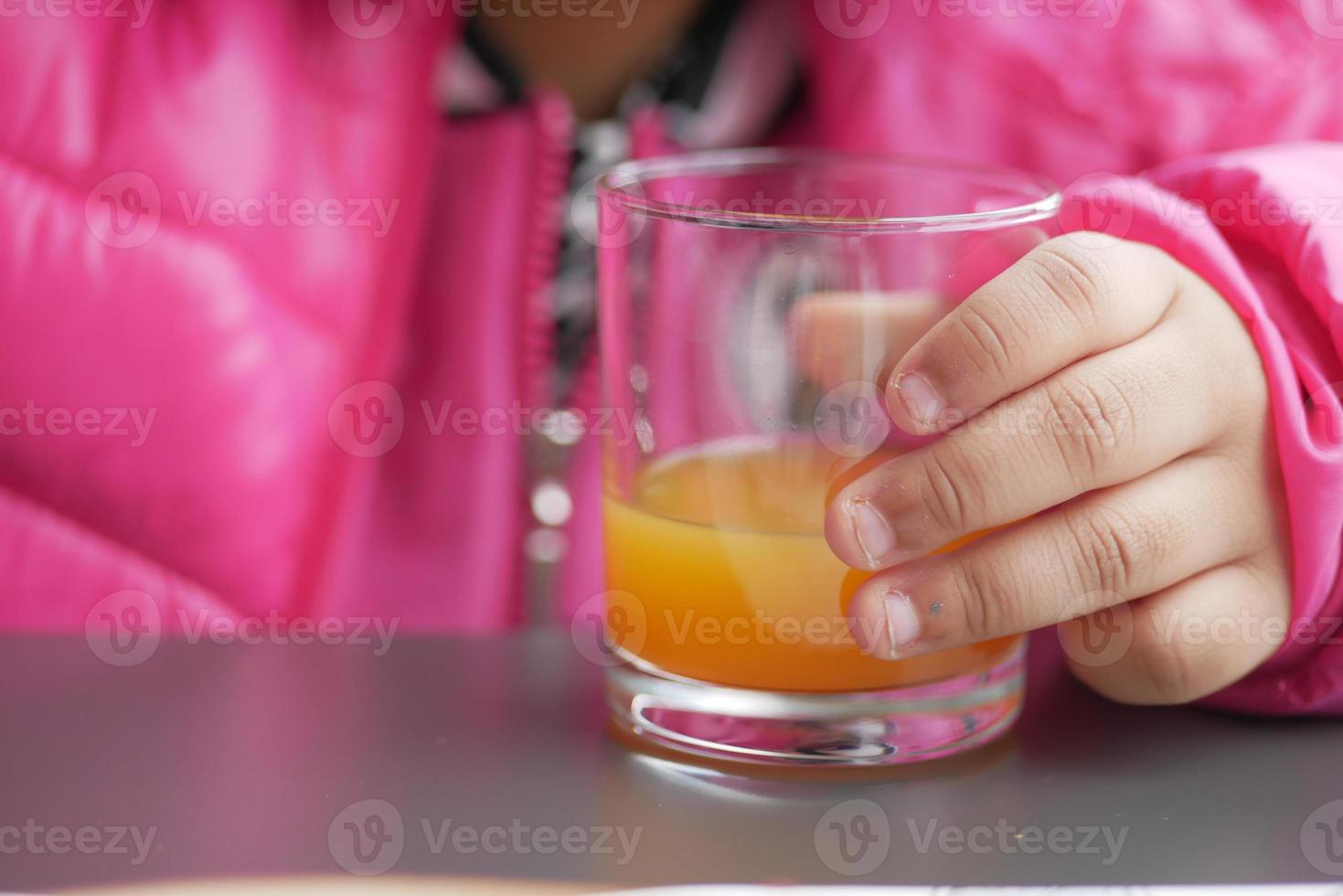 Kind halten ein Glas von Orange Saft foto