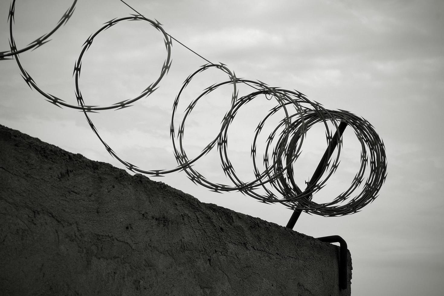 Stacheldraht an der Wand in schwarz und weiß foto