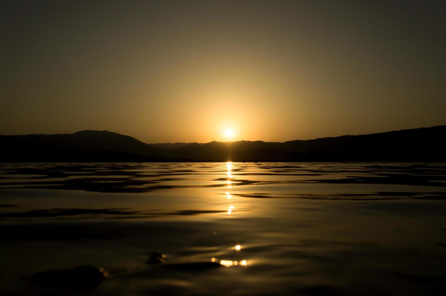 Blick auf einen See mit dem Sonnenlicht auf der Wasseroberfläche reflektiert foto