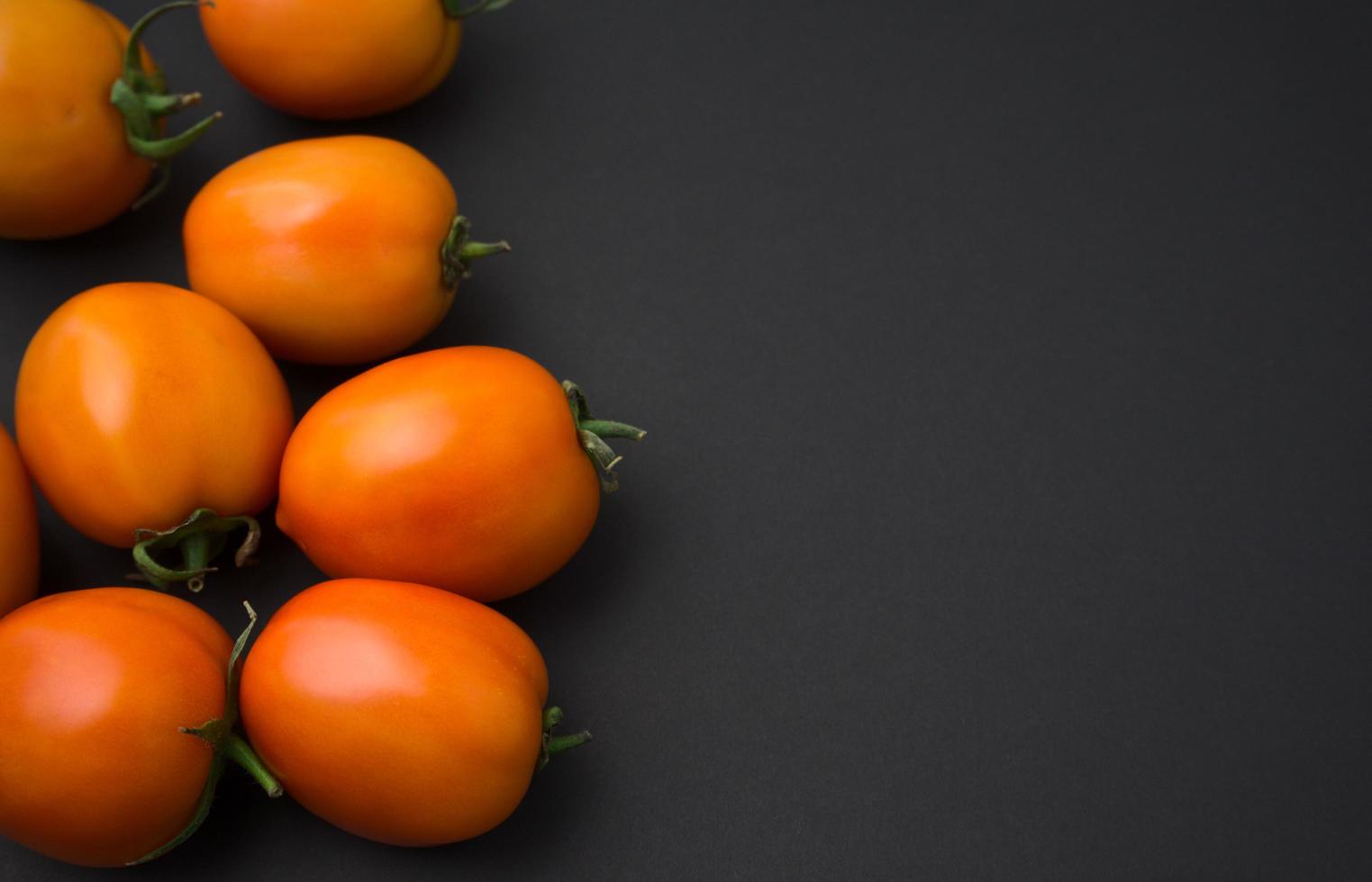 Tomaten flach lagen auf schwarzem Hintergrund. foto