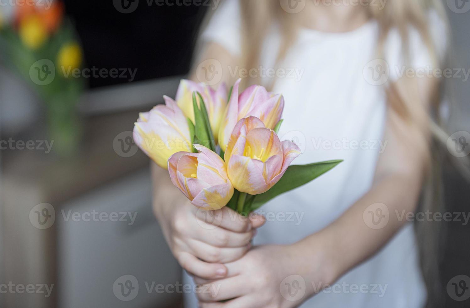 Frühlingstulpen in den Händen eines kleinen Mädchens. foto