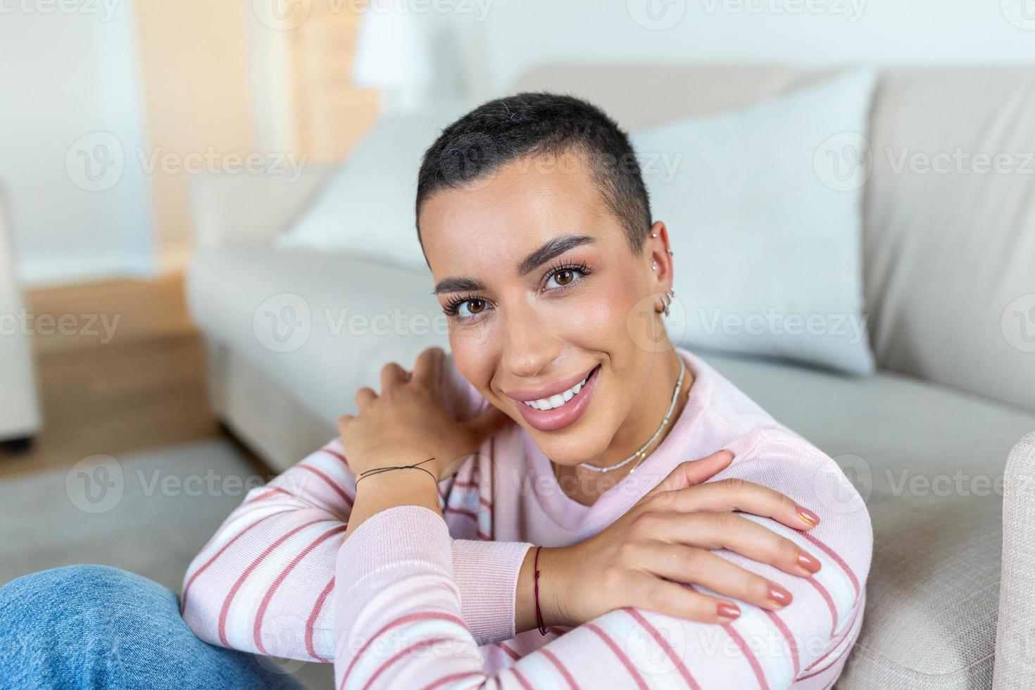 Porträt von ein schön Frau lächelnd beim heim. afrikanisch amerikanisch Frau im beiläufig suchen beim Kamera mit Kopieren Raum. heiter gemischt Rennen Mädchen entspannend beim Zuhause mit groß lachen. foto