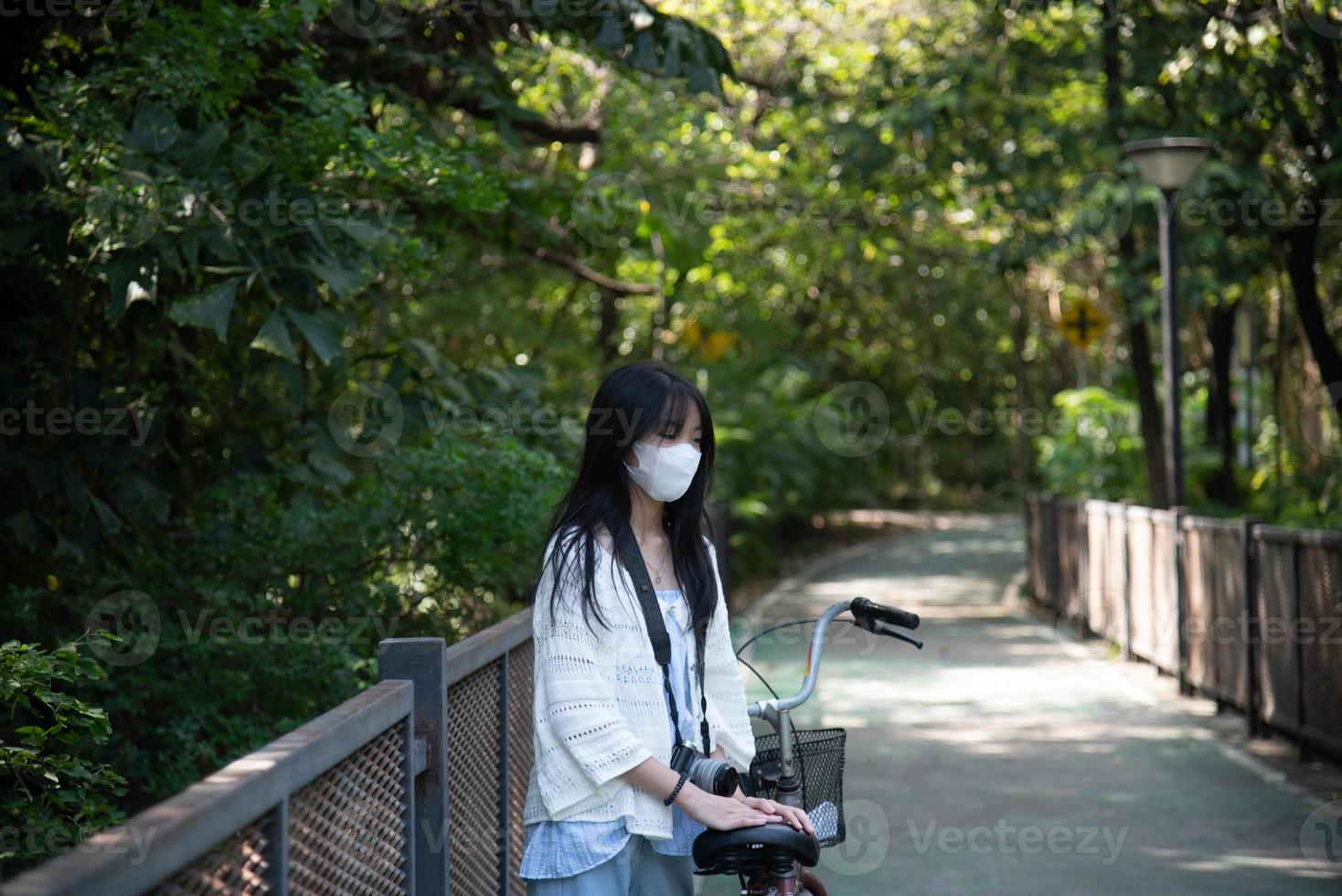 asiatisch Frau Reiten ein Fahrrad im das Park. foto