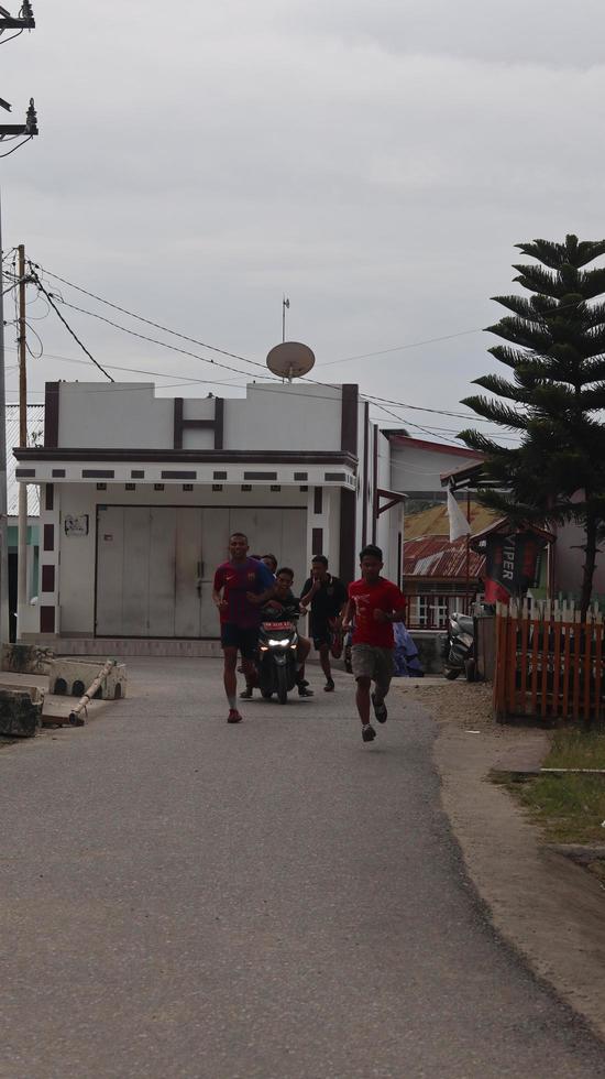 Gorontalo, März 2023 - - Marathon- Laufen Wettrennen, Menschen Füße auf Stadt Straße. Laufen Menschen beim ein Marathon- Wettbewerb foto