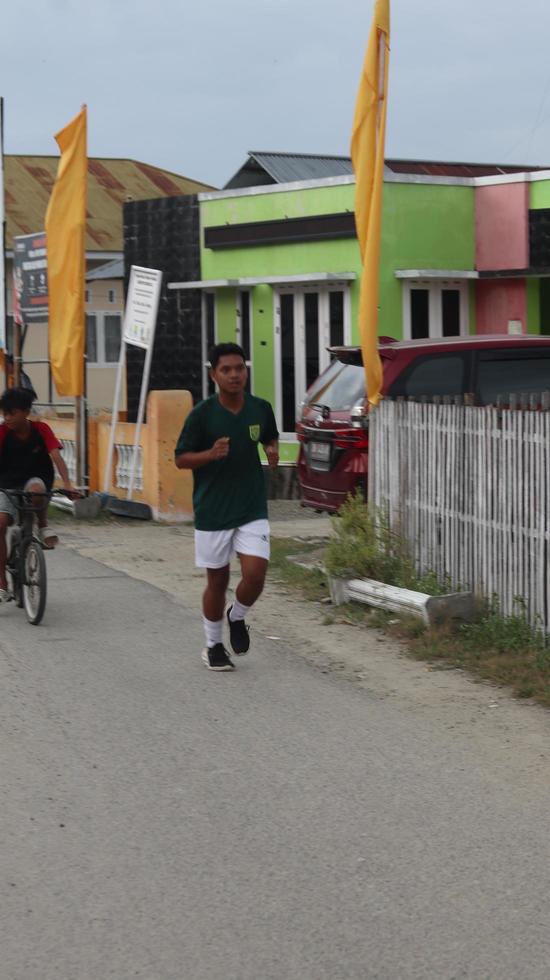 Gorontalo, März 2023 - - Marathon- Laufen Wettrennen, Menschen Füße auf Stadt Straße. Laufen Menschen beim ein Marathon- Wettbewerb foto