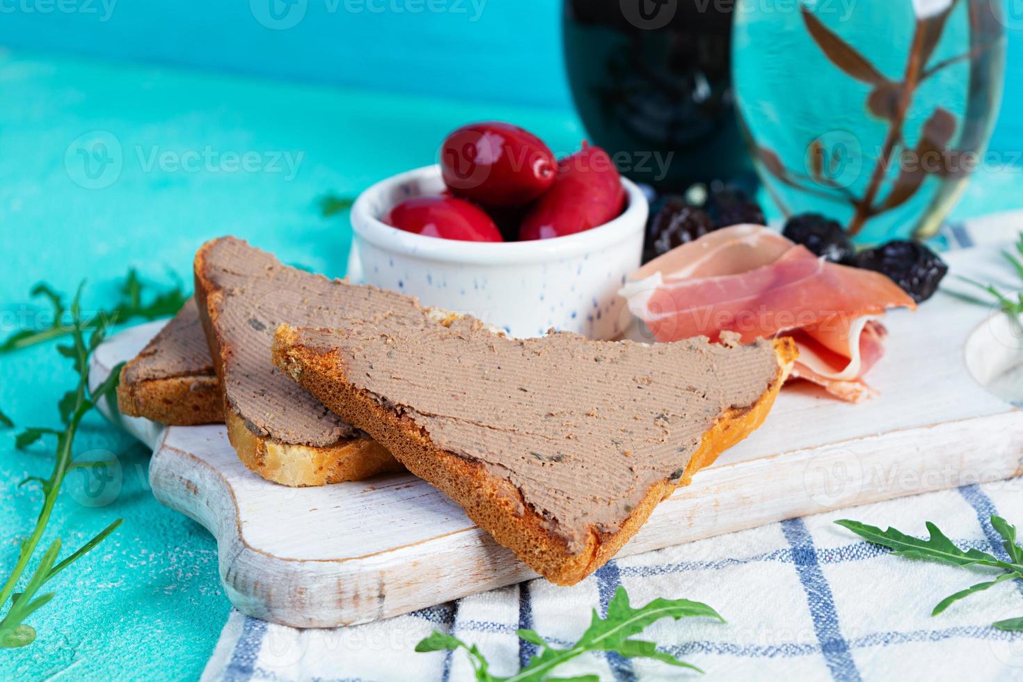 gegrillt Sandwich mit Pastete mit Hähnchen Leber und Oliven auf Blau Hintergrund foto